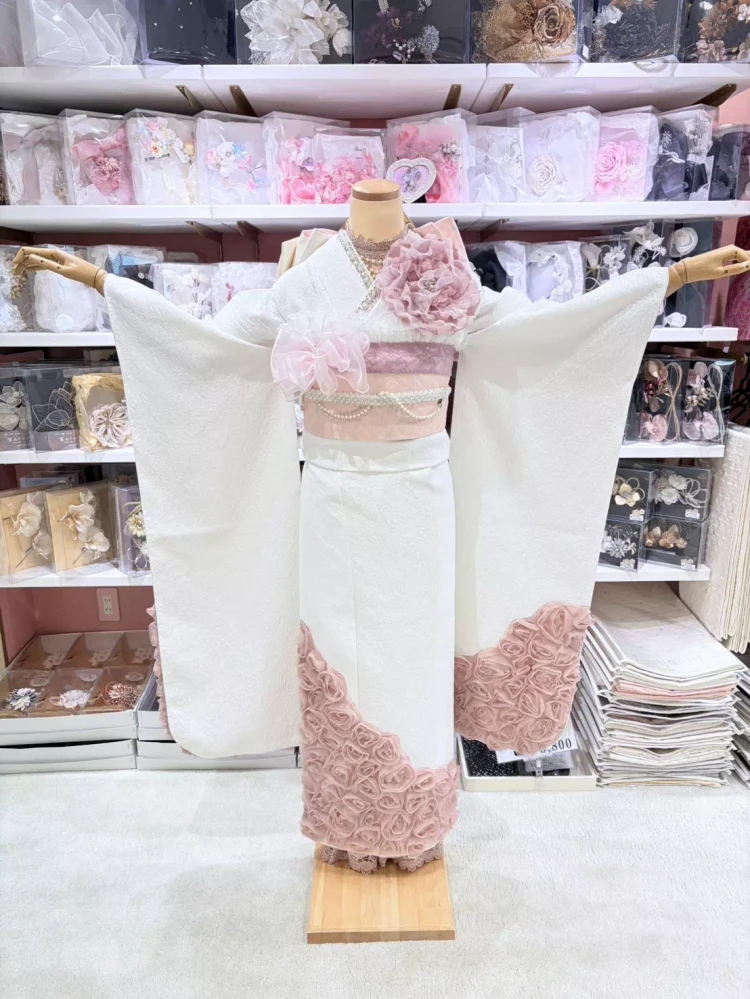 姫路のTAKAZEN姫路店で取り扱う淡色系ローズ振袖。立体フラワー装飾、くすみピンク配色、ホワイトベースのデザインで、人と被らない大人ガーリーな成人式向け振袖コーディネート