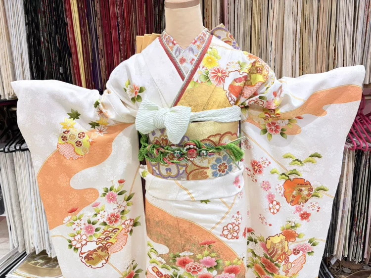 TAKAZEN姫路店の王道古典のお振袖。白地にオレンジと吾０ルドの華やかな柄が入ったお振袖です。