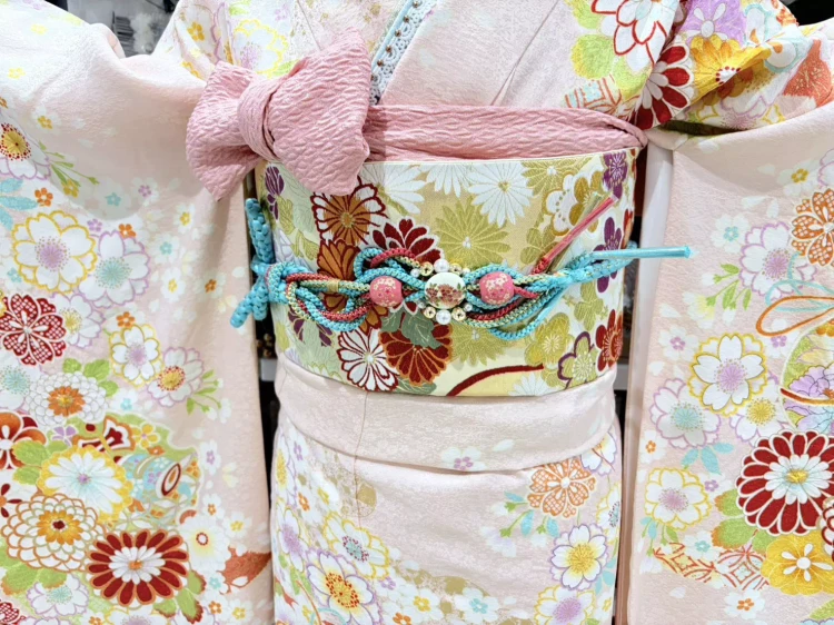 TAKAZEN姫路店の淡いサーモンピンクの可愛い古典柄振袖。桜や菊などが描かれたお振袖。