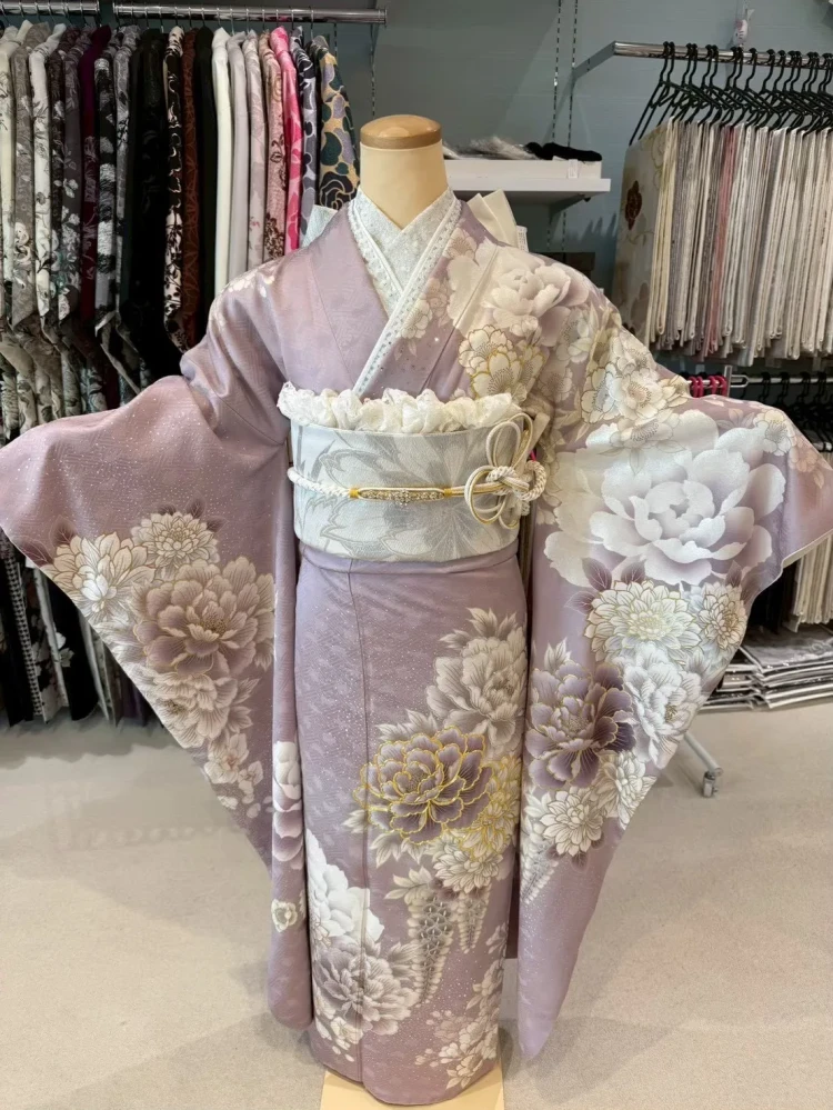 くすみピンクの地に大柄の牡丹や菊の花が描かれた上品な振袖に、アイボリーの帯を合わせたおすすめコーディネート。やわらかい色味と華やかな花柄が特徴で、卒業式や特別な日にぴったりの大人かわいいスタイル。