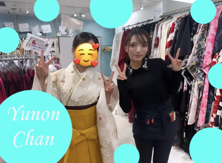 白地に淡い花柄の着物×からし色袴コーデを試着されたお客様とスタッフのツーショット。店内でピースサインをしながら卒業式袴選びを楽しむ様子。