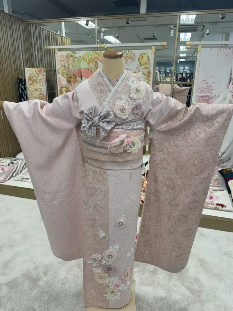 すみピンクの総レース振袖に立体フラワーをあしらったガーリーな振袖コーデ。リボン帯やレース小物を合わせた、トレンド感あふれるフェミニンスタイル。