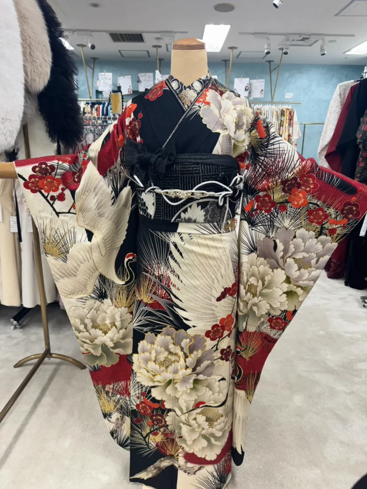 黒×白×赤の古典柄振袖コーディネート。牡丹や梅、鶴が描かれた豪華な振袖に、黒の帯と白の帯締めを合わせた上品で華やかなスタイル
