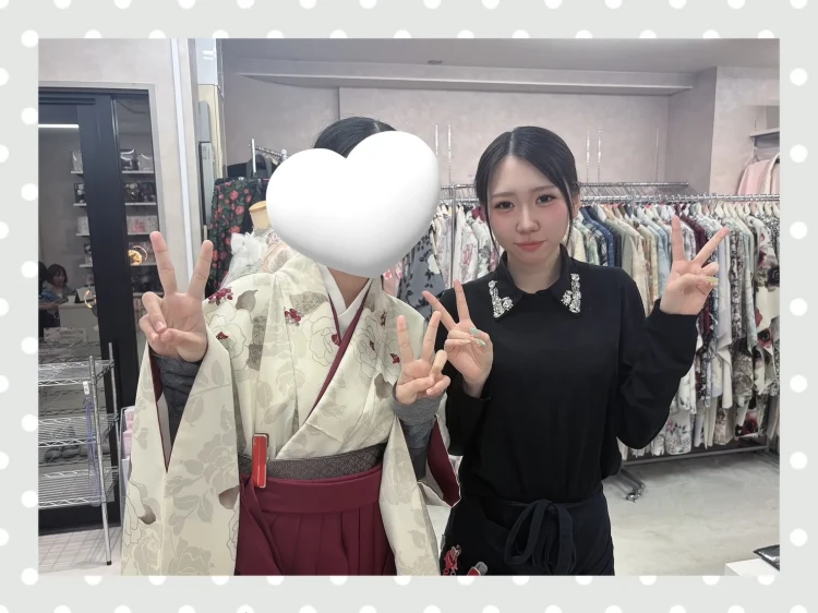 くすみカラーの今っぽ小振袖にえんじ色の袴を合わせたコーディーネートを試着されるお客様の様子