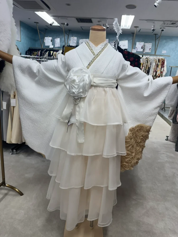 白の無地振袖にゴールドの重ね衿と白いコサージュを合わせた上品で華やかなコーディネート