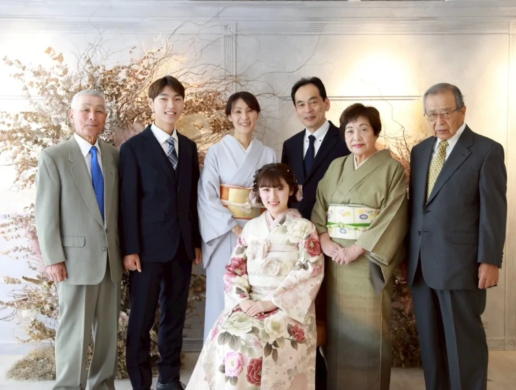 淡い色合いの振袖を着たお嬢様と、ご家族が一緒に撮影した集合写真。祖父母やご家族に囲まれた、成人式の大切な節目を感じられる一枚。