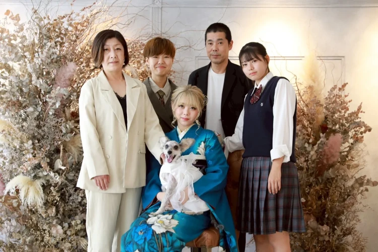 鮮やかなブルーの振袖を着たお嬢様を中心に、ご家族とペットが一緒に写った家族写真。大切な家族の一員である愛犬と残す、思い出いっぱいの一枚。