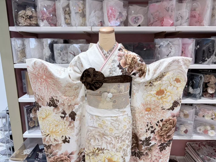 TAKAZEN姫路店の着物メーカーブランドの白地にピンクやブラウンのお花が描かれたおしゃれ振袖コーデ