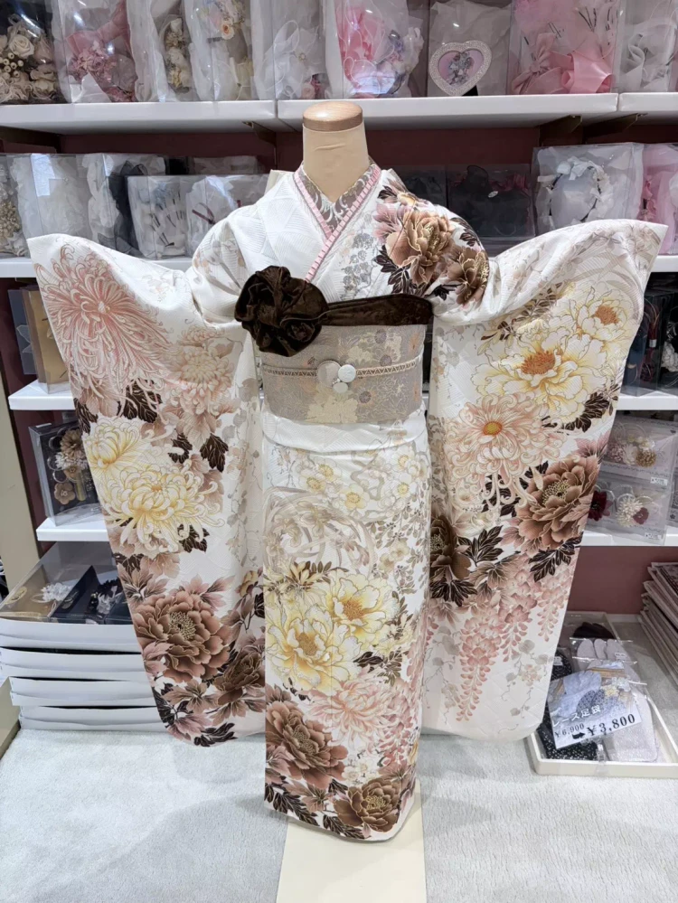 TAKAZEN姫路店の着物メーカーブランドの白地にピンクやブラウンのお花が描かれたおしゃれ振袖コーデ