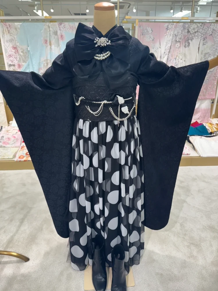 ブラックレーベルの黒い振袖コーデ。大きな黒いリボンとパールの帯飾りを合わせた華やかな振袖スタイル