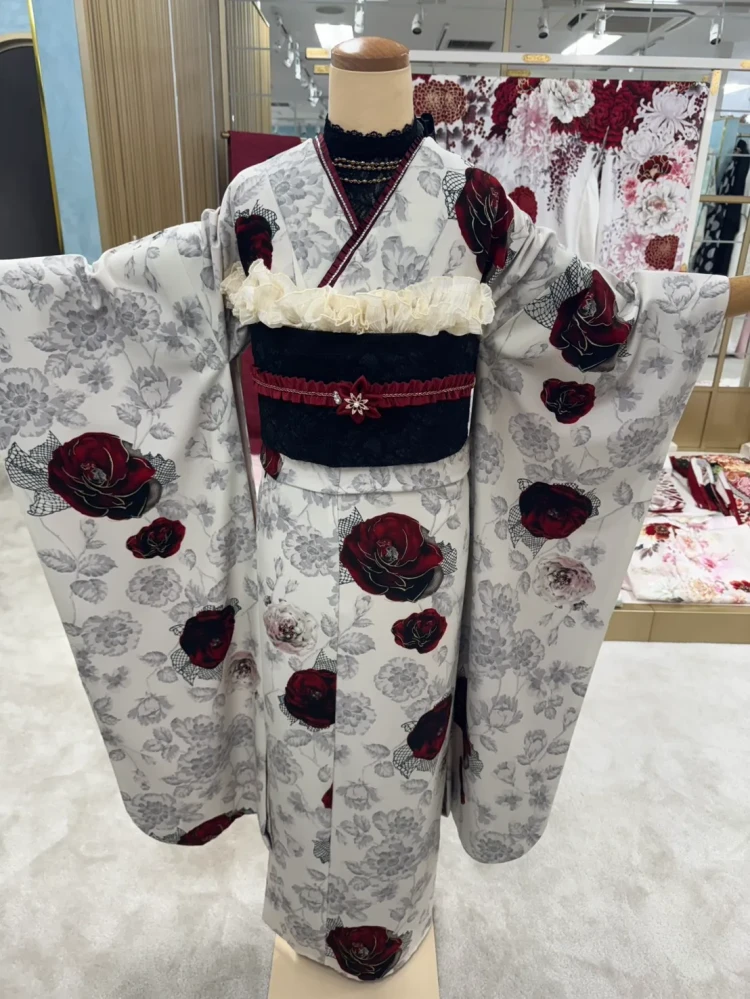 白地にグレーの花柄と深紅の薔薇をあしらった大人っぽい振袖コーデ。黒の帯とボルドーの帯締めを合わせたモノトーン×赤の華やかな着こなし
