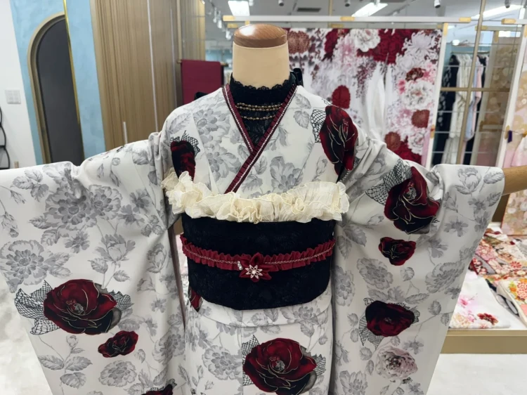 白地にグレーの花柄と深紅の薔薇をあしらった大人っぽい振袖コーデ。黒の帯とボルドーの帯締めを合わせたモノトーン×赤の華やかな着こなし