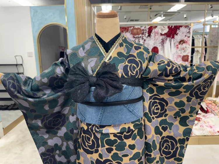 くすみグリーン・ベージュ・ネイビーの薔薇やハート柄が印象的な個性派振袖。デニム風の帯とブラックリボンを組み合わせた、レトロモダンでスタイリッシュな振袖コーディネート。